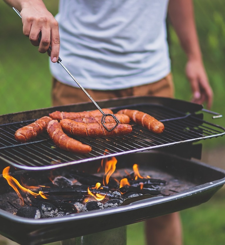 Man on a bbq grilling sausages