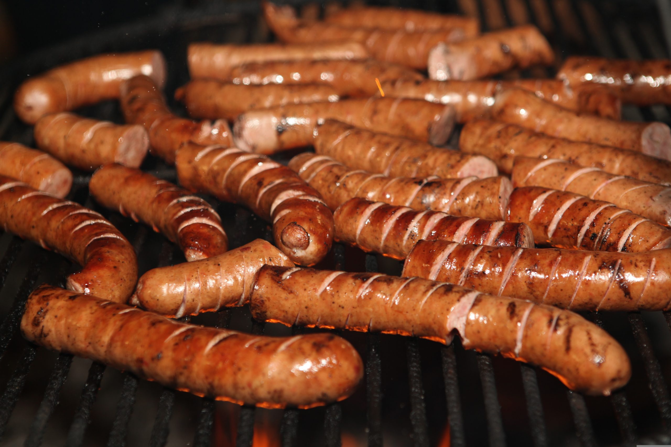 loads of frankfurters on a bbq