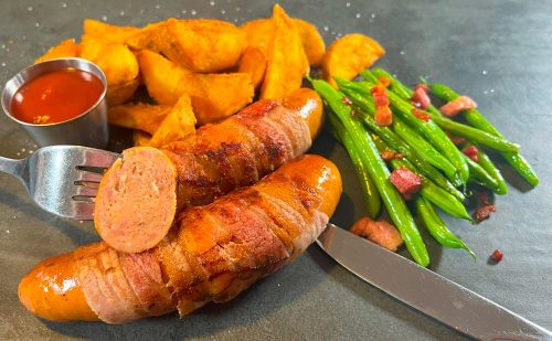 Pigs in blanket with potato wedges and beans