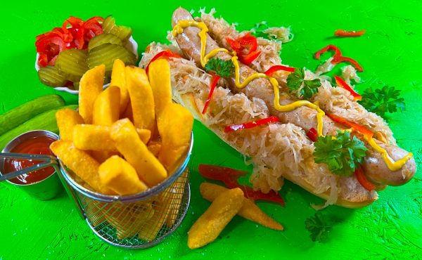 German Bratwurst hotdog with sauerkraut, mustard, and crispy chips by The Sausage Haüs.