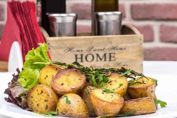 Golden roasted potatoes seasoned with herbs and pepper — showing the difference between bratkartoffeln vs roasted potatoes in texture and style
