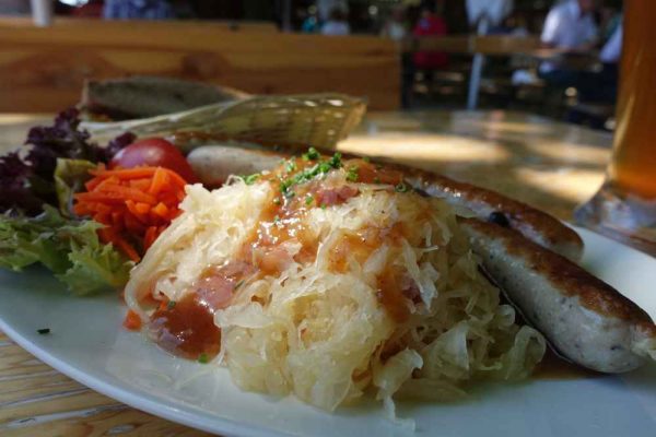 Traditional German bratwurst with sauerkraut on a plate — classic combination from authentic German sausage suppliers in the UK