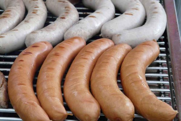 Authentic German Frankfurters on a grill showing the difference between a hot dog and a frankfurter.