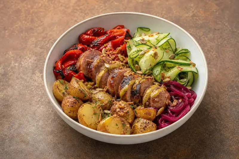 A seasonal curry bratwurst bowl with potatoes, vegetables, and light curry-mustard dressing.